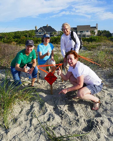 Voluntarios con el equipo de Isle of Palms/Sullivan's Island celebran el primer nido de la temporada del estado. (Foto por Barb Bergwerf)