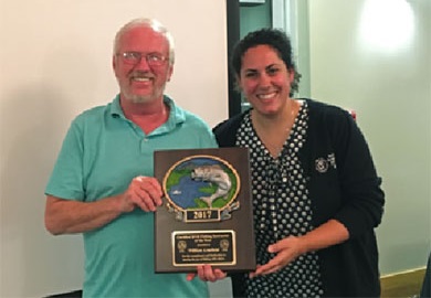 La Coordinadora de Educación Acuática del SCDNR, Sarah Chabaane presentó el galardón de Instructor de Pesca del año SCDNR a William 'Billy' Armfield.
