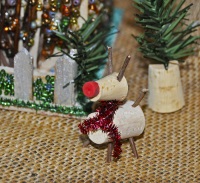 Rudolph the Red Nosed Deer has an eraser nose, twigs to make the legs, antlers and tail, bottle corks, and a red scarf made from sparkle pipe cleaner.