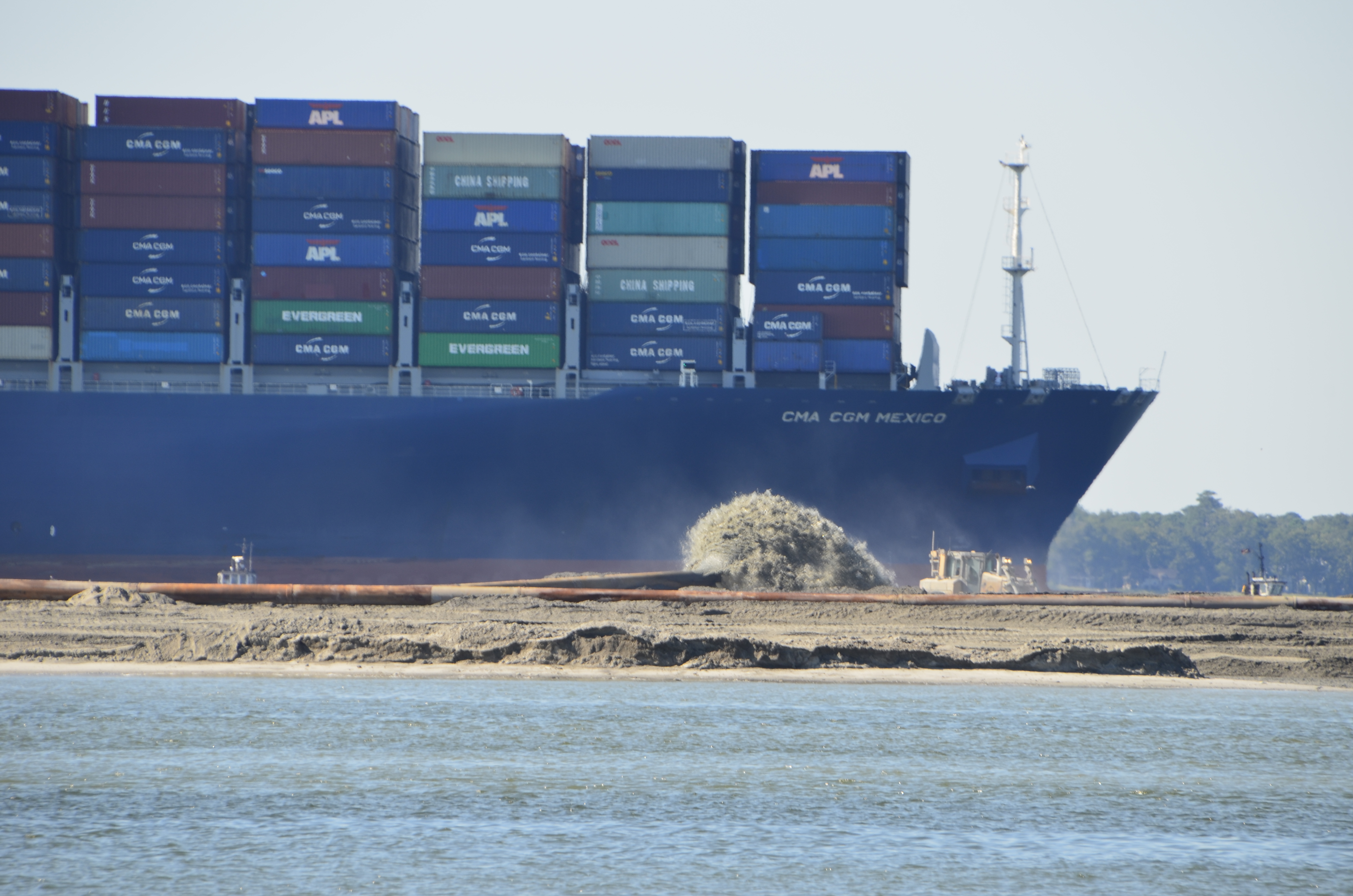 A loaded container ship on its way to the Port of Charleston passes by Crab Bank Seabird Sanctuary while work to restore the island is underway in October of 2021.
