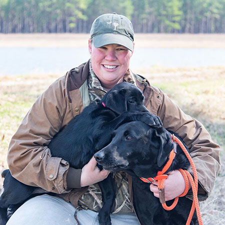 Molly Kneece poses with still-puppy Kate and Willie for a South Carolina Wildlife magazine photo shoot in early 2019. (SCDNR photo by Taylor Main)