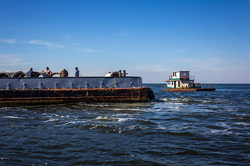 Concrete culvert pipes (left) and retired tugboat (right) preparing to join the McClellanville Reef roughly 10 miles offshore. (Photo: Kaitlyn Hackathorn/SCDNR)