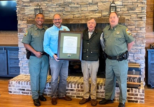 Norman Pulliam is presented with a plaque by agency director Robert Boyles.