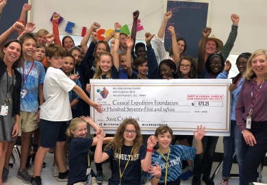 Students present check to Coastal Expeditions after raising money for the Crab Bank renourishment project. (Photo by Chris Crolley)