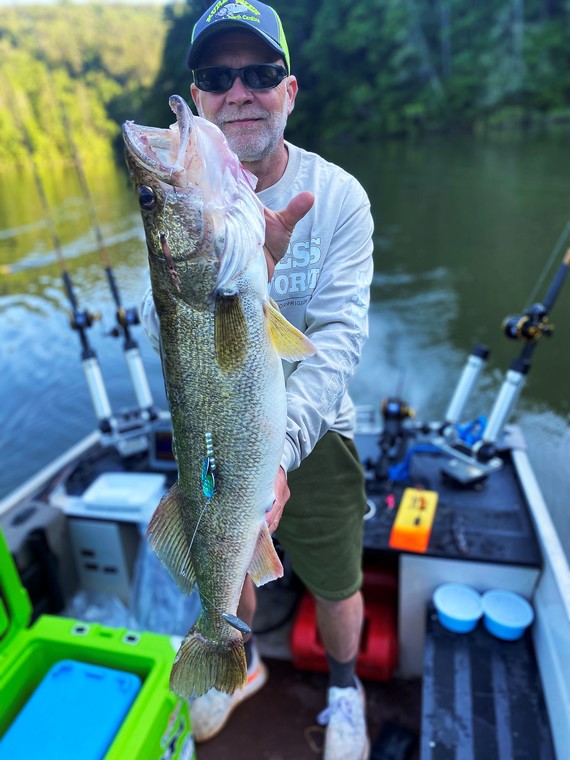 man holding walleye on a boat