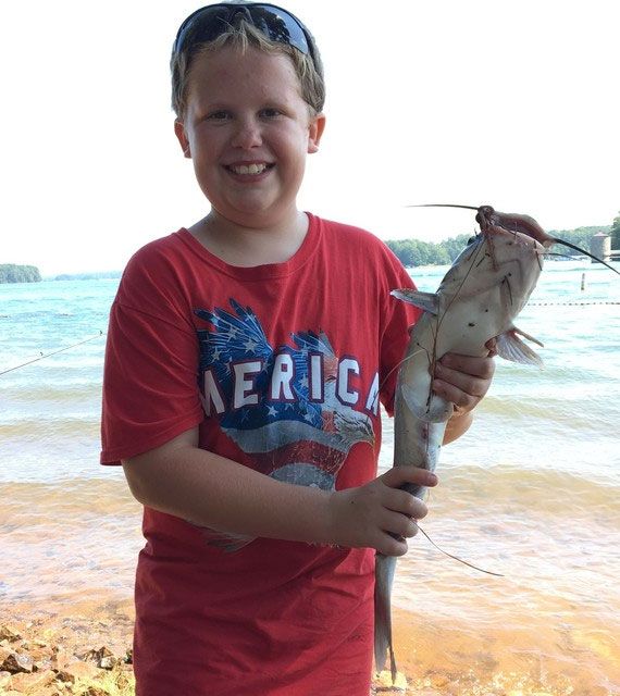 Photograph of boy showing caught fish