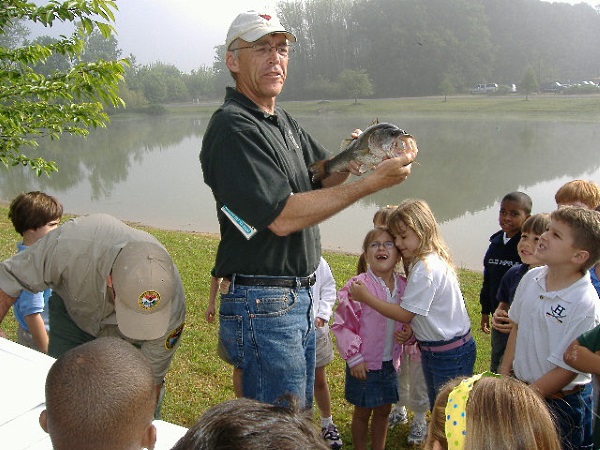 Jim Bulak showing a largemouth bass to students