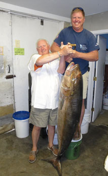 Photograph of Record Amberjack with Angler John Beauford on the left in white shirt, owner and captain Michael Owen on right holding fish
