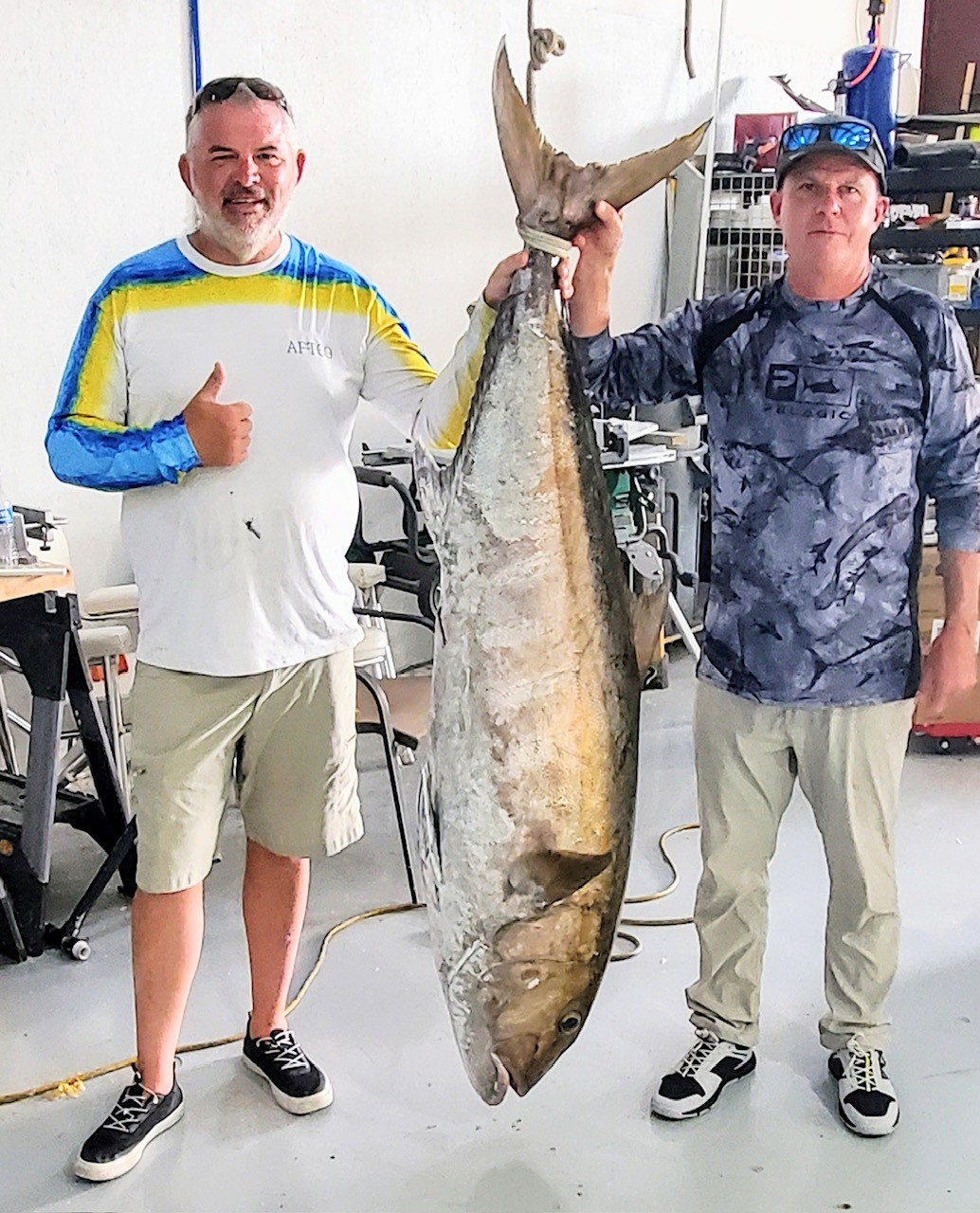 Photograph of Record Amberjack with Angler John Beauford on the left in white shirt, owner and captain Michael Owen on right holding fish