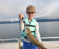 Smiling kid holding a brown trout