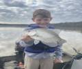 Smiling kid holding a black crappie