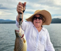 Smiling lady holding a brown trout