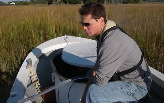 Tyler Grespin prepares to release juvenile red drum into the marsh along the Wando River