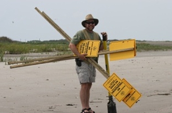 Volunteers helping to put up signs along a beach